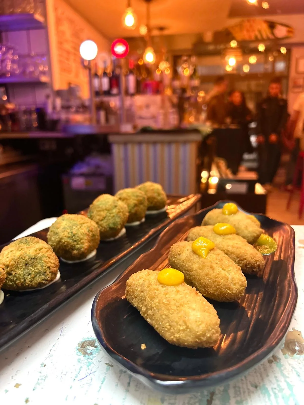 Dos fuentes de croquetas artesanas sobre la barra de Sa Croqueteria